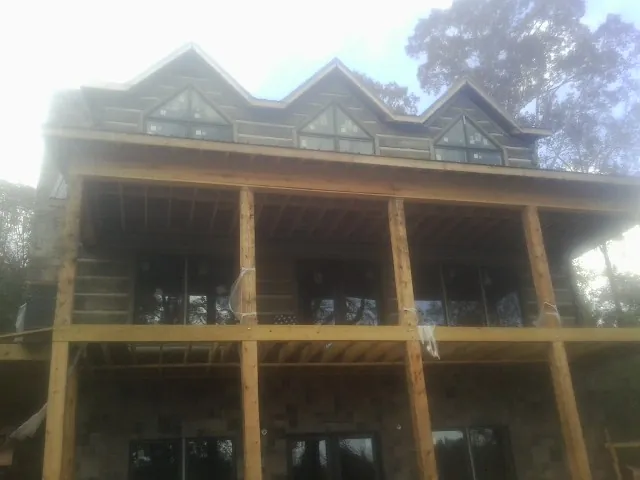 Dormers and porch framing on a large log home under construction — Roof Coating work by our crew in Terre Hill