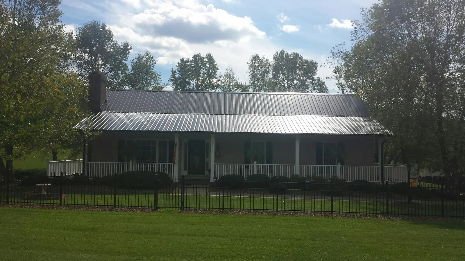 Gray metal roof on a brick ranch with a full width front porch — Gutter Guard Installation work by our crew in Terre Hill